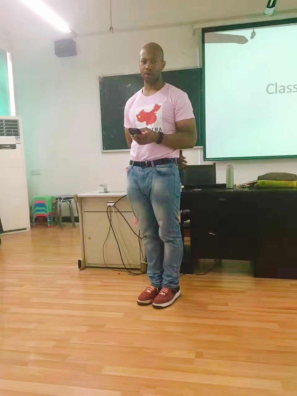 Danny Flight standing in his classroom in China, where he taught for years without an expensive certificate