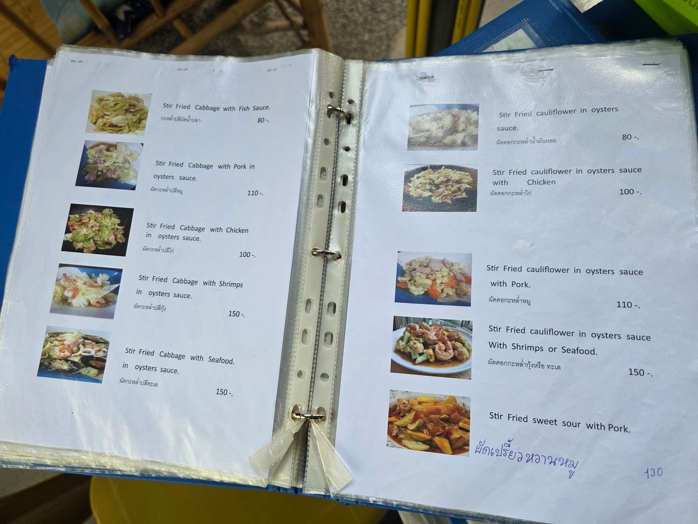 A Thai menu spread photographed by Danny Flight showing stir-fried cabbage and cauliflower dishes from 80 to 150 baht.