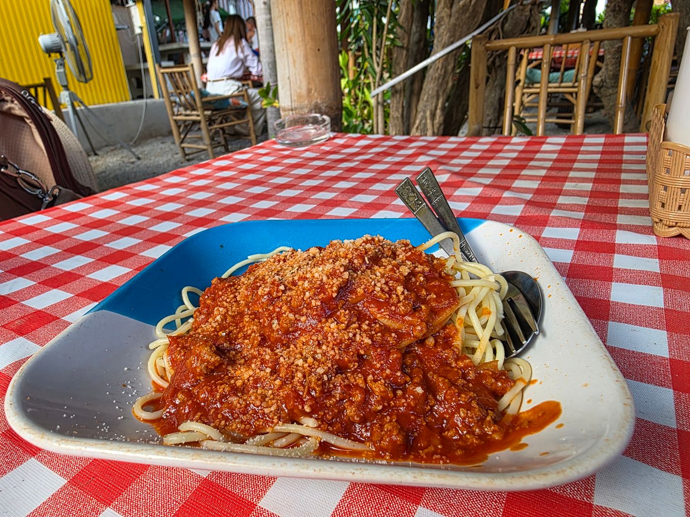 A plate of spaghetti bolognese with parmesan at an open-air Thai garden restaurant, photographed by Danny Flight.